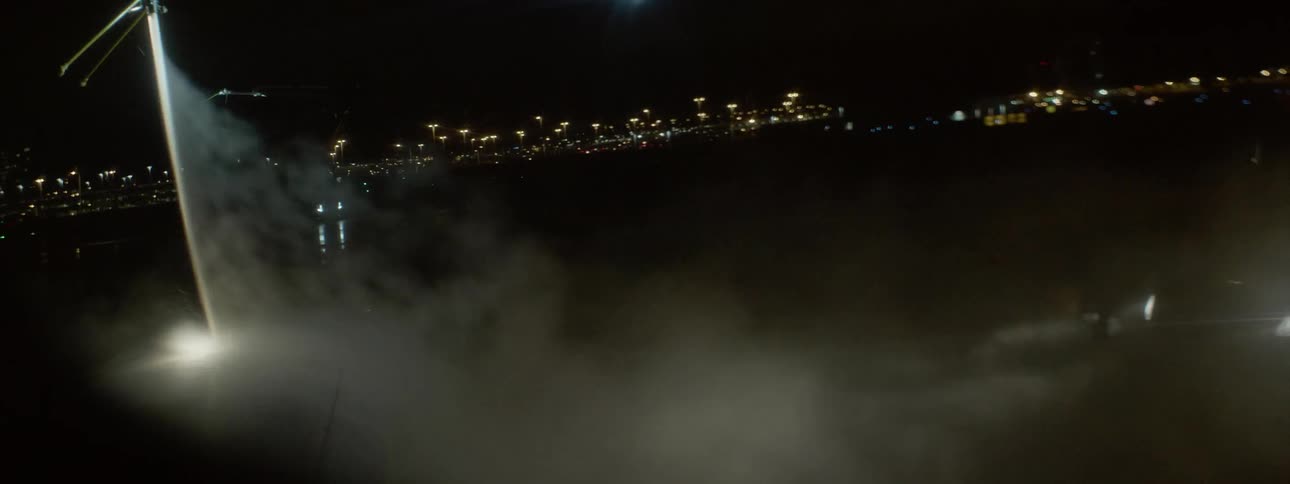 An aircraft lowers toward the ground and sprays a substance