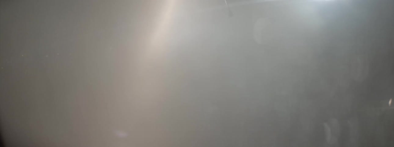 Water sprays down from a helicopter in the night sky