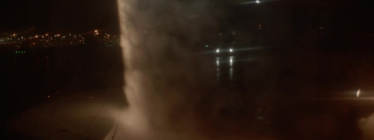 An elevated hose sprays high pressure liquid down to the ground