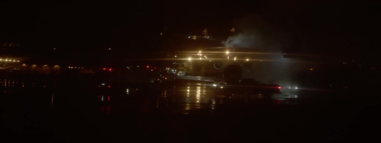 Plane stands on the take off field surrounded by cars at night