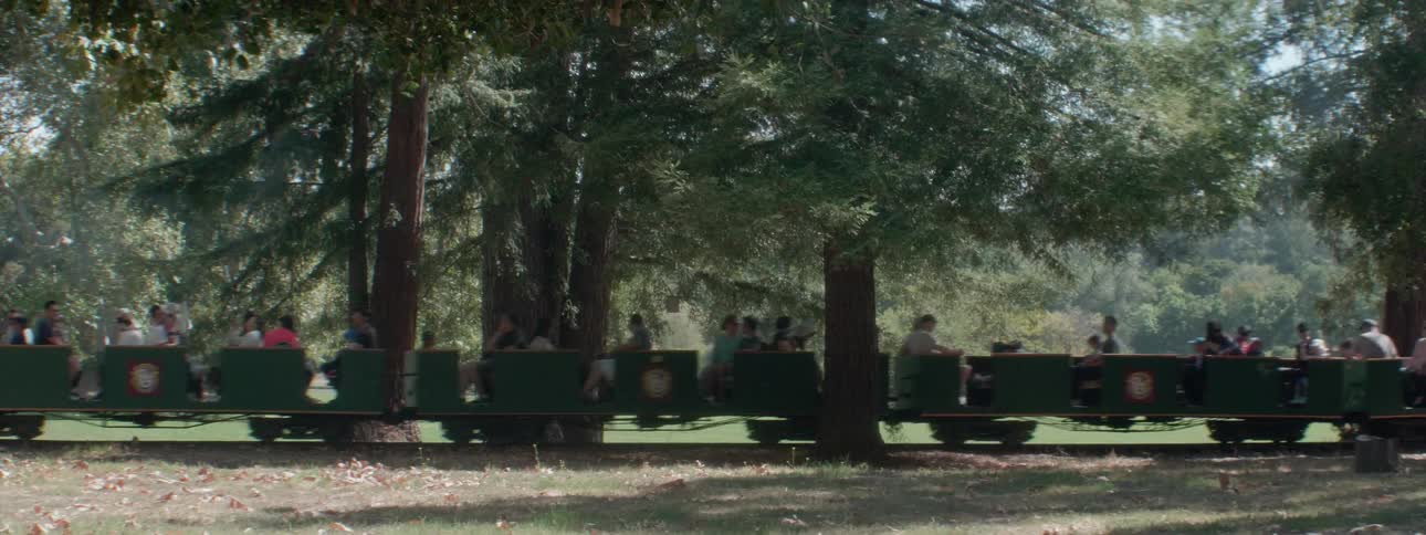 A small train pulls cars full of people