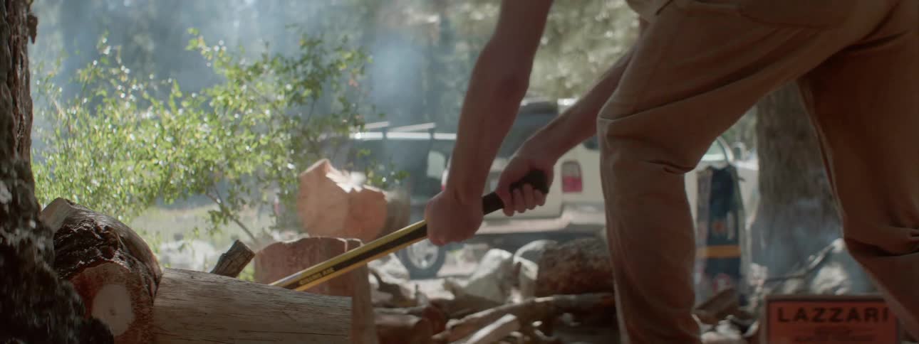 A person splits a log with a maul
