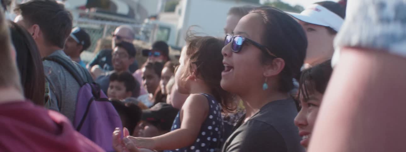 A crowd of spectators are enjoying watching some type of outdoor event