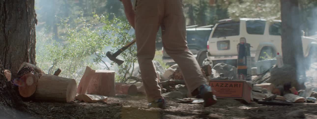 Man cuts wood with an ax in the forest