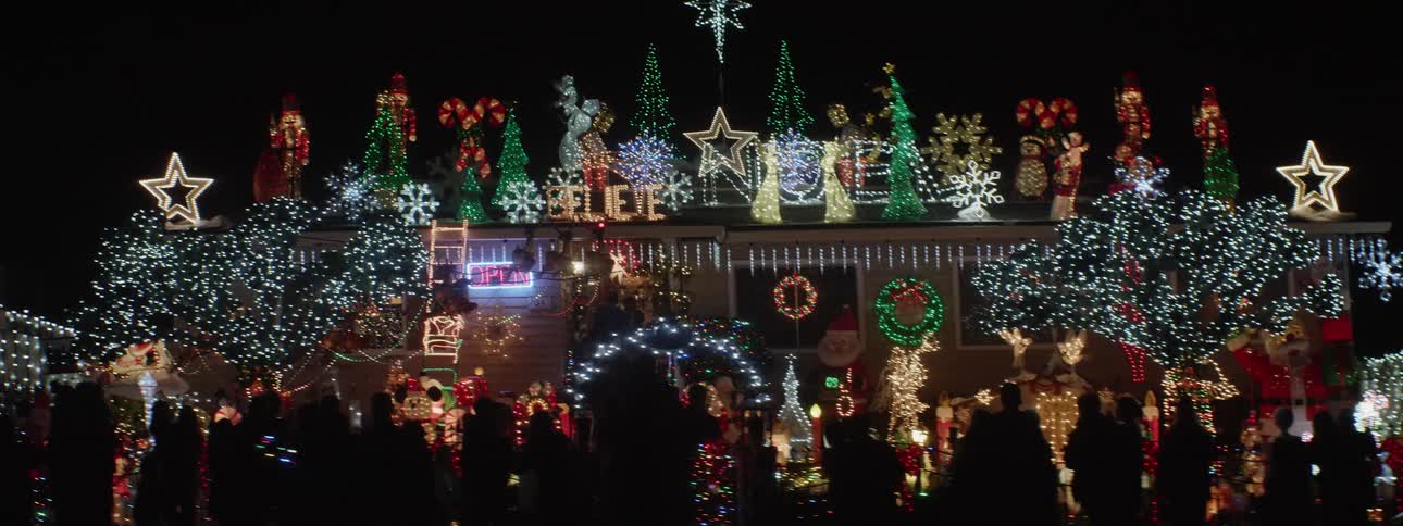 People waiting outside of a building covered in christmas decorations