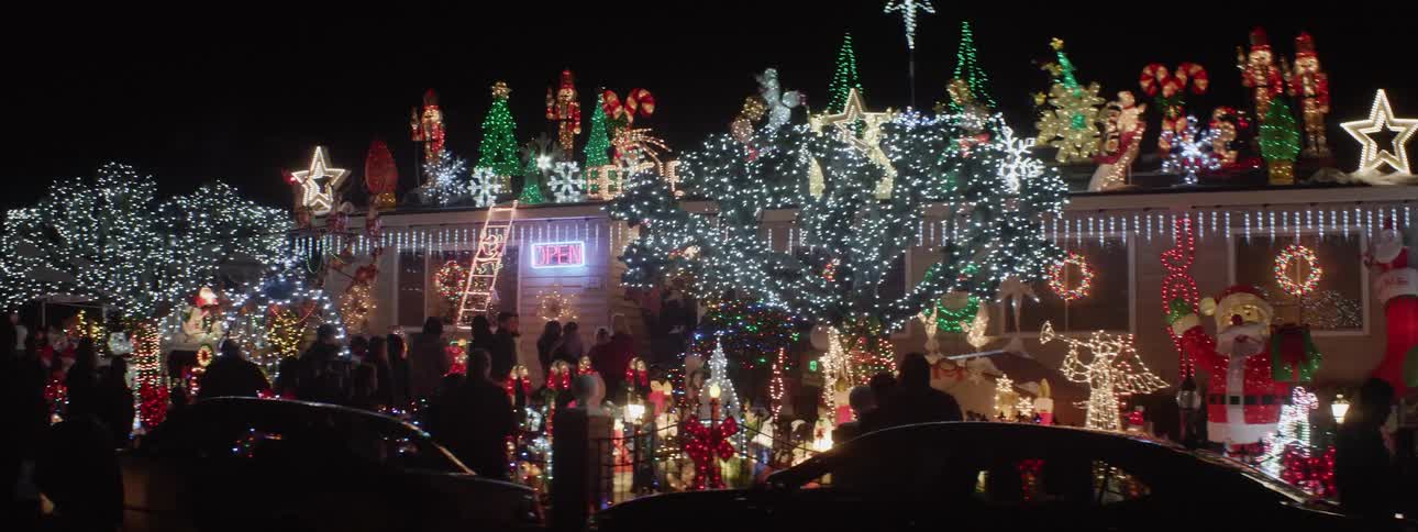 People visit a house covered in holiday decorations