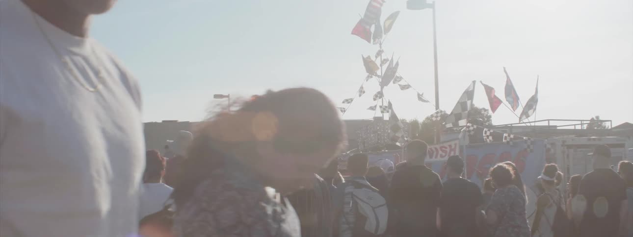 A group of people stand together watching a show outside