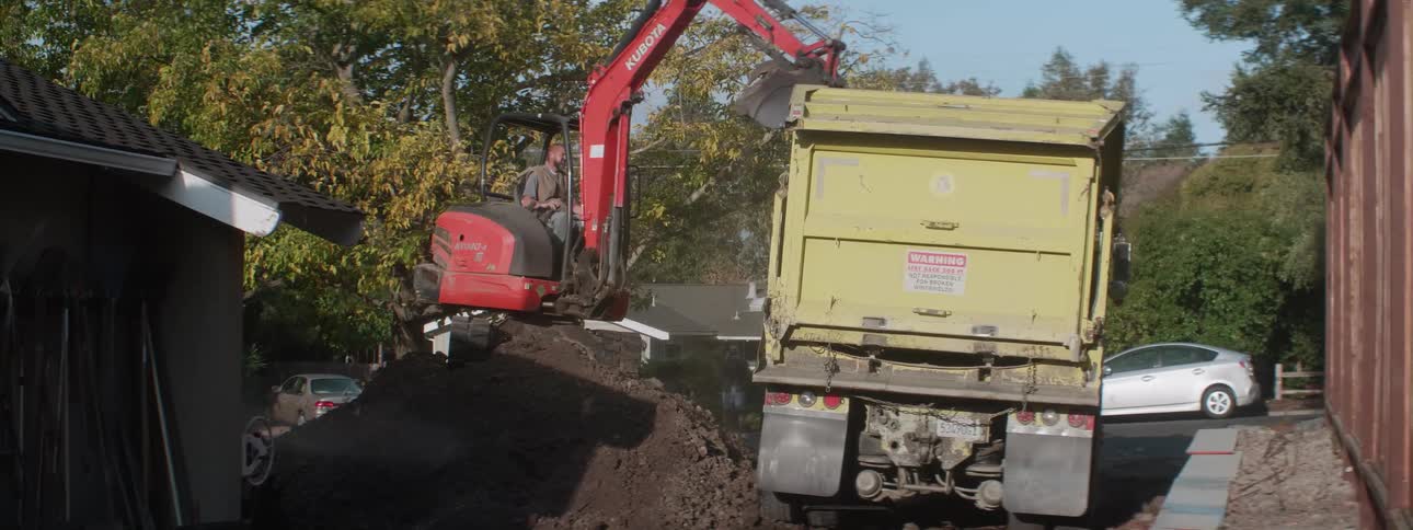 Two work trucks filling dirt
