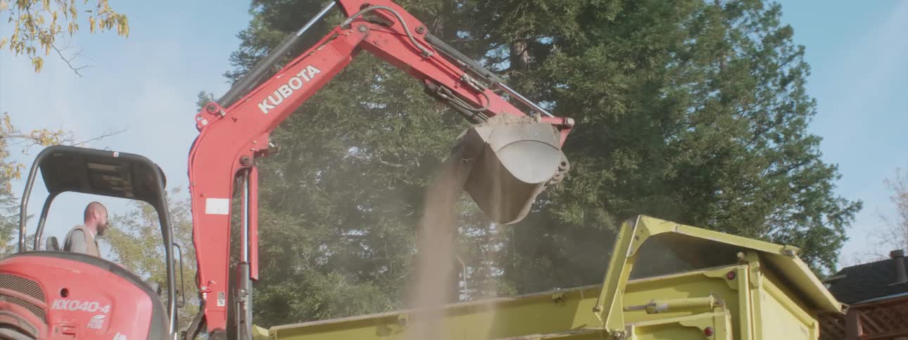 A man is using a machine to move dirt
