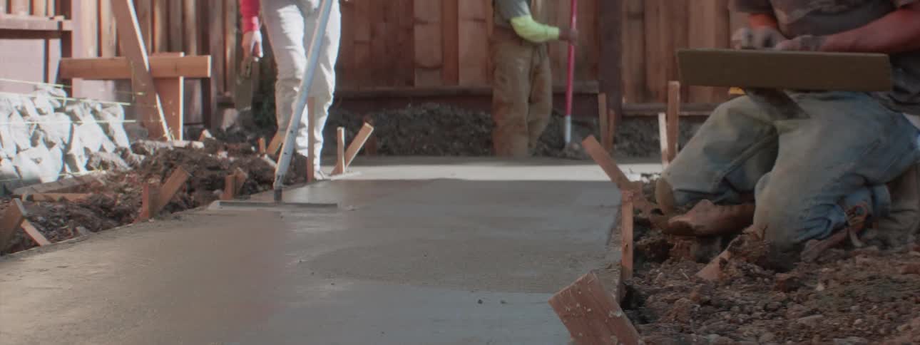 A man flattening wet concrete