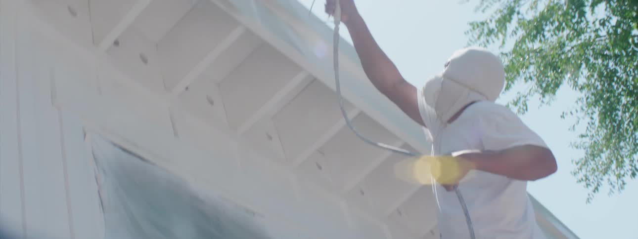A person painting the exterior of a house
