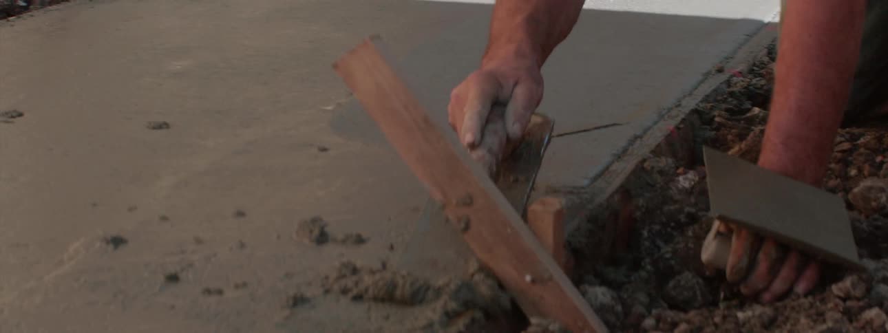 A man smoothing out wet concrete