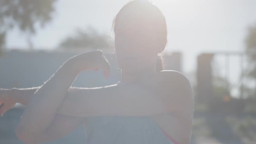 A woman stretches her left arm
