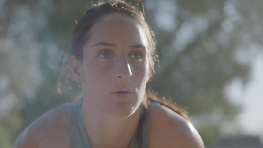A woman rests to catch her breath after exercising outside