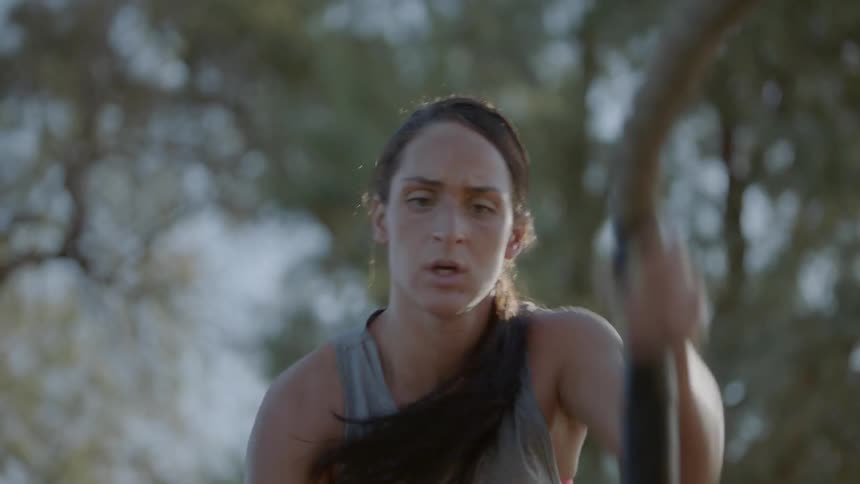 Woman working out with battle rope outdoors