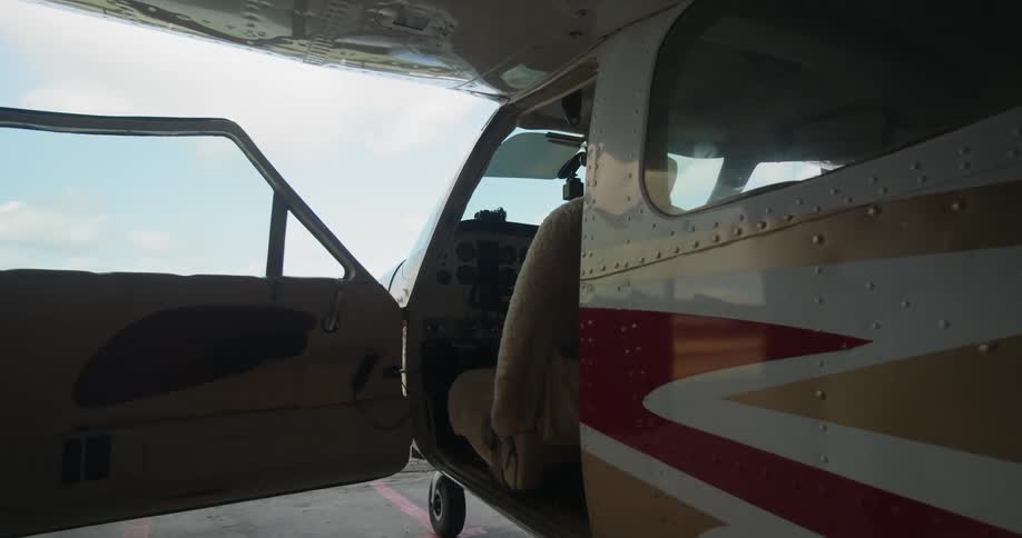 Pilot carries bags and boards airplane on runway