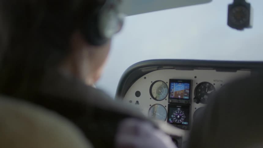 Pilot sitting in a cockpit flying a small plane