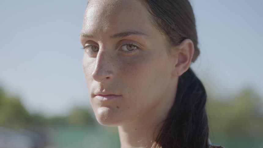 A woman stares into the camera