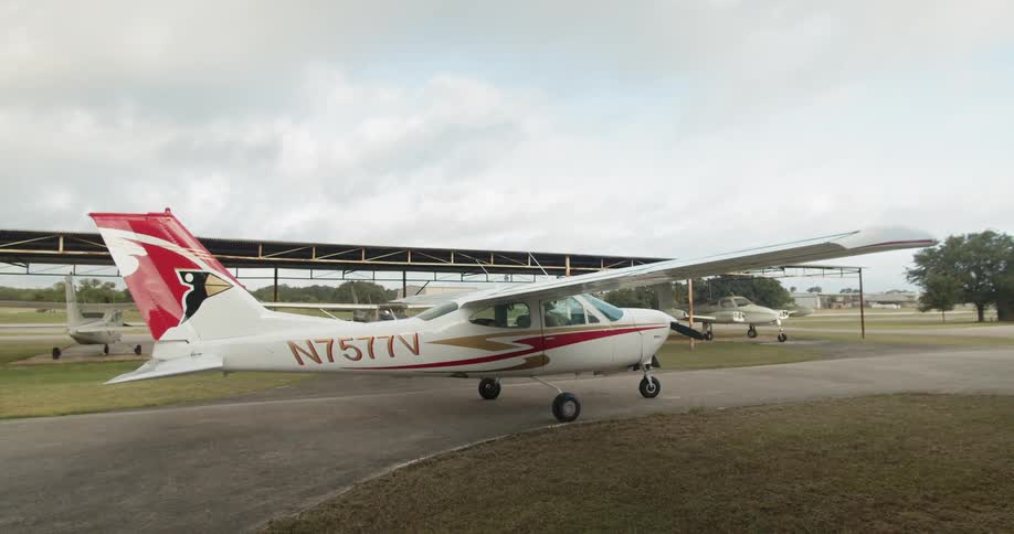 Airplanes in an airport with trees and the sky in the background
