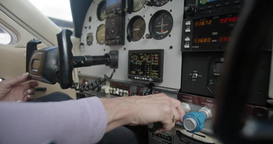 A white man pilots a small airplane