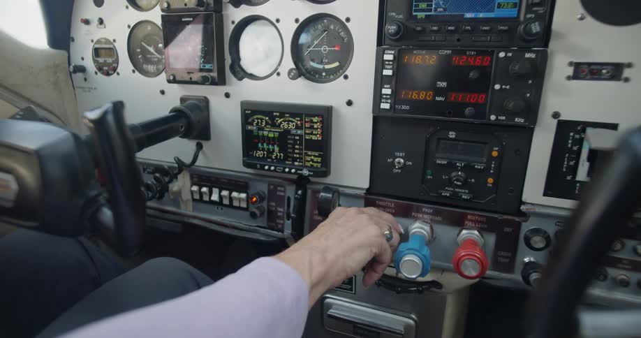 A man uses the controls inside an airplane