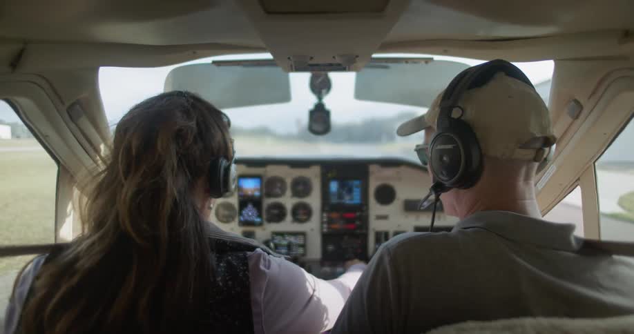 A man and woman start up the plane on the runway