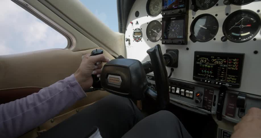 A man holds on to the controls and flies a plane