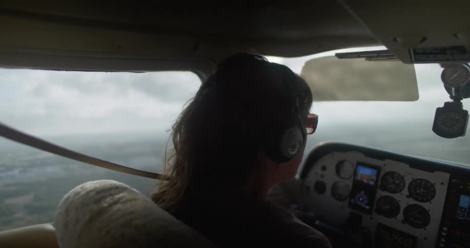 A woman rides in the cockpit of a small airplane