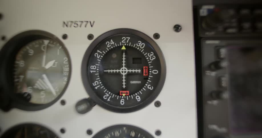 Several gauges and switches are on a silver and gray dashboard