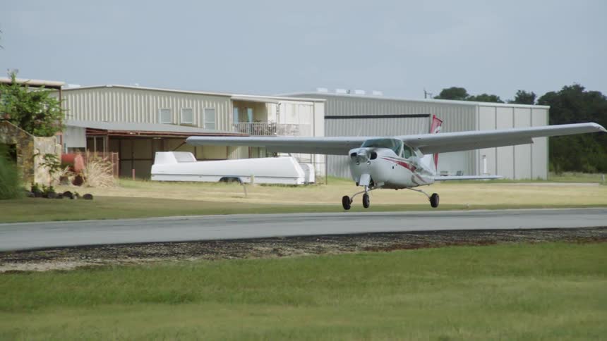 Cessna plane landing on a runway at a small airport in a rural area