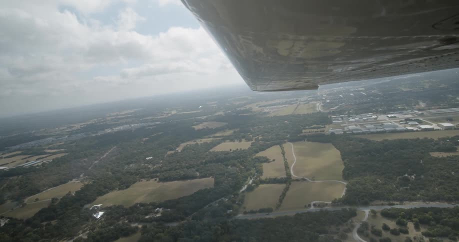 A birds eye view of a town below from an aircraft