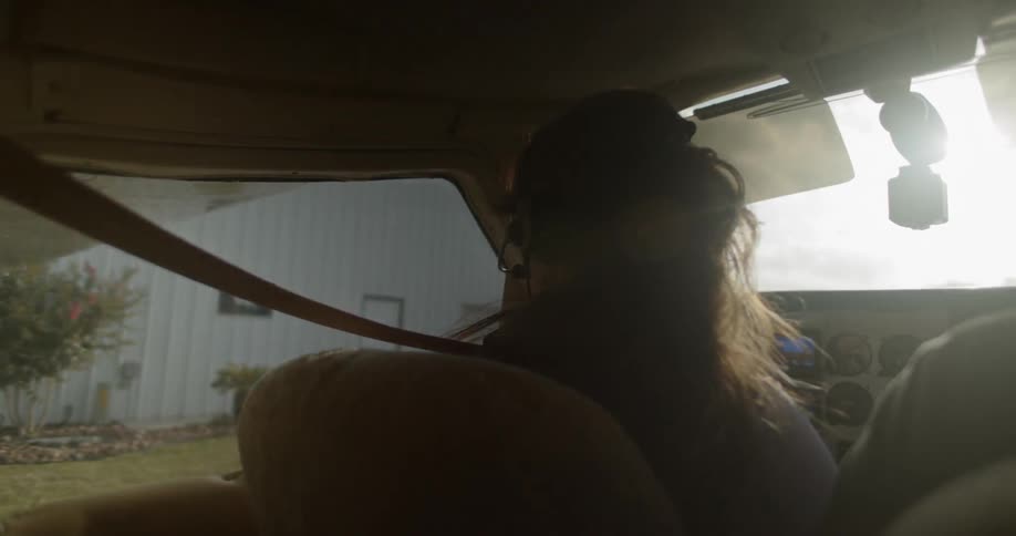 A woman rides in the cockpit of a small airplane