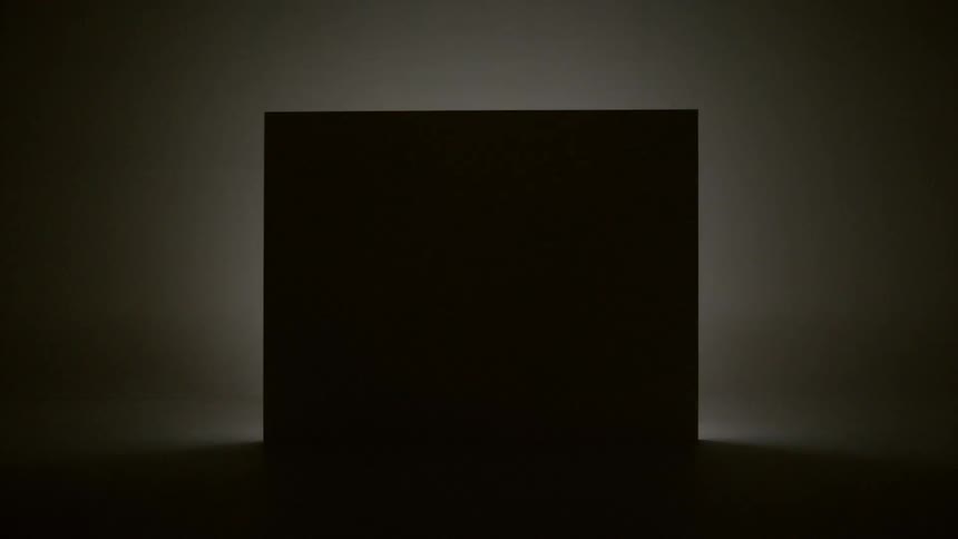 A black box is silhouetted in a room