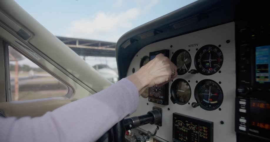 A person is turning the dials inside a plane