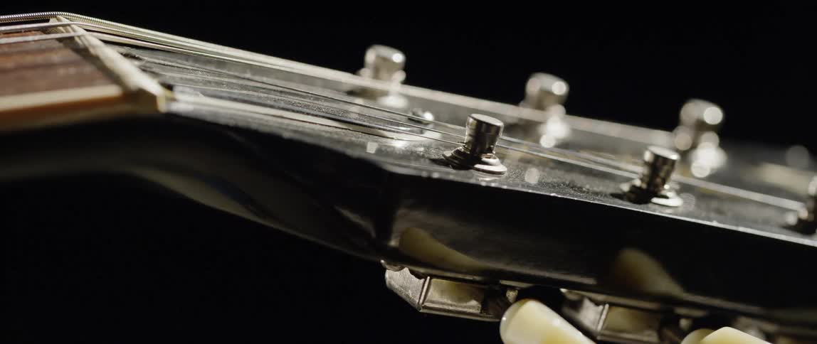 The head of a guitar is shown with strings on it