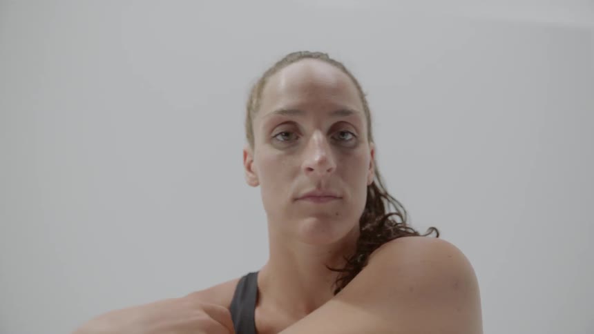A white woman stretches her arm