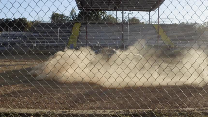 A car spins in a circle in a dirt track