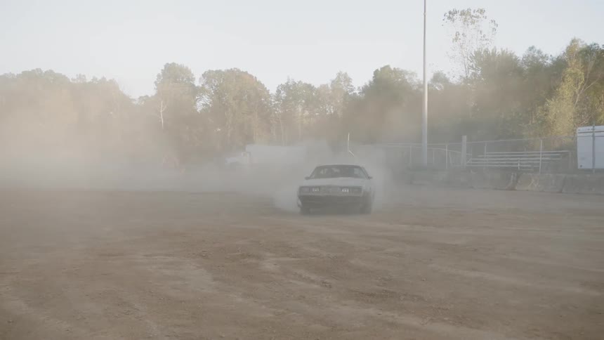 A car races in a dirt arena