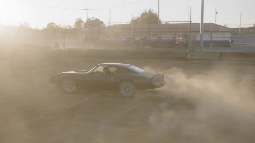 Moving shot of a car on a dirt field