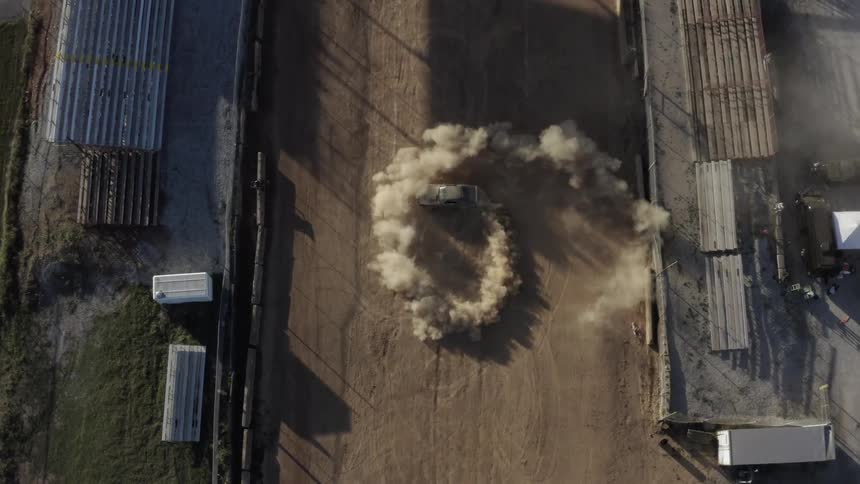 A dusty car spins cookies in a dirt arena