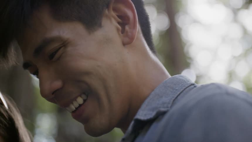 A man smiles and looks at a woman