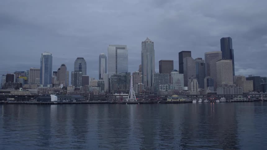 A river flows in front of city buildings on a cloudy day