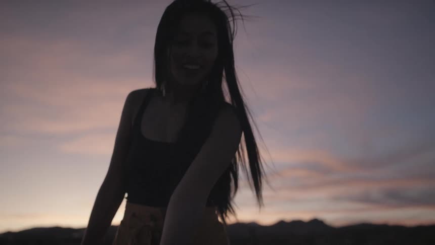 A young woman swings a tube around as powder releases from it