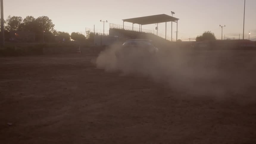A car races in a dirt field