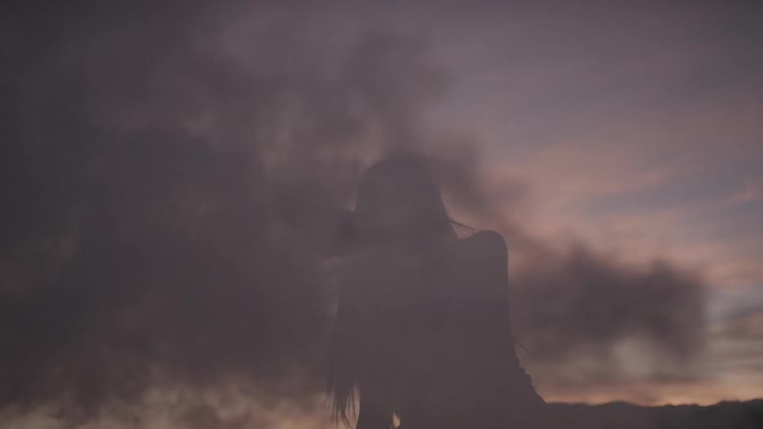 A woman is dancing outdoors