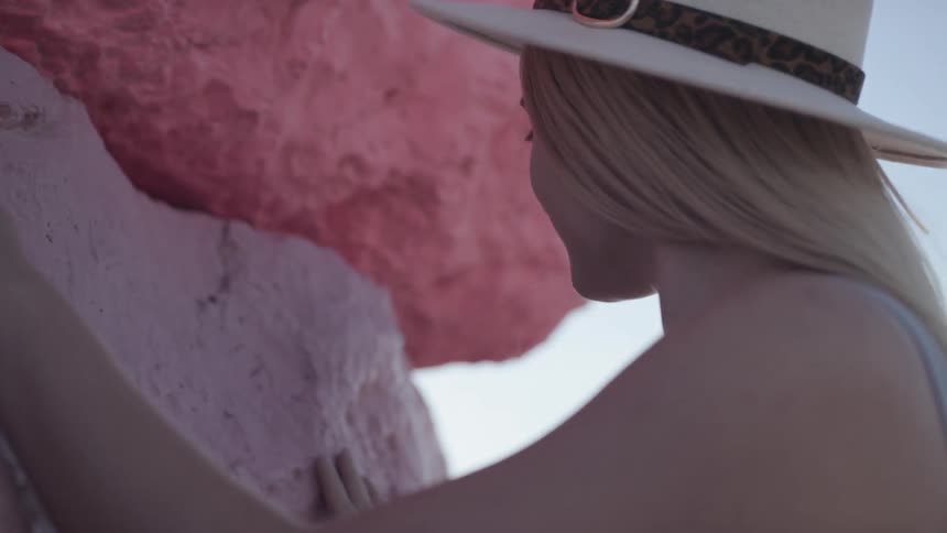 A woman touches a large rock