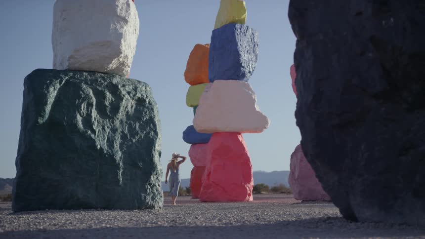 A woman walks through colorful rocks