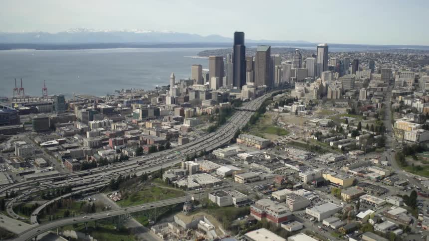 Cars drive on a highway system in a large city