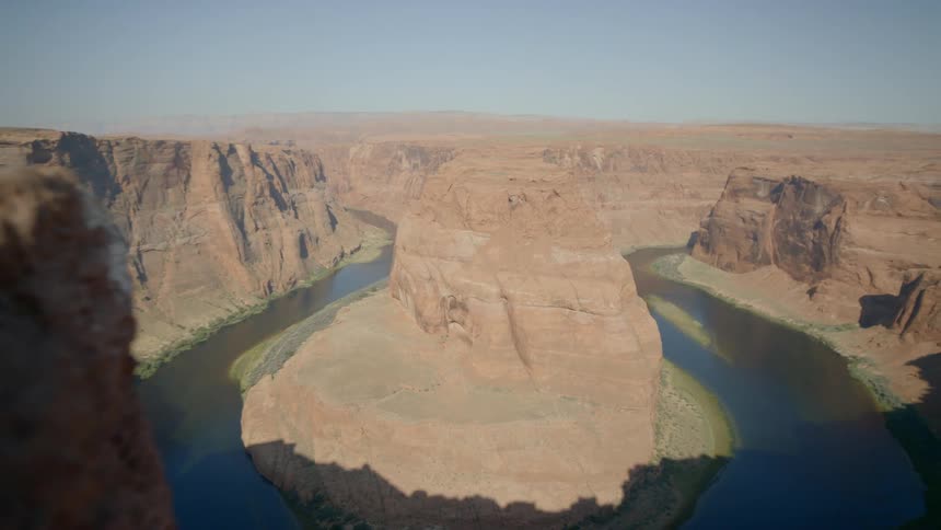A river flowing around either side of a mesa in a canyon