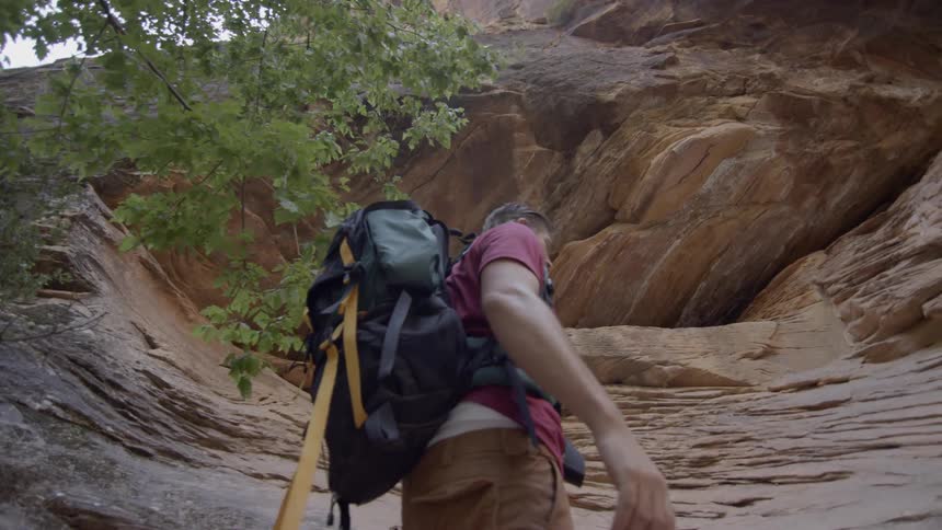 A man is hiking past the canyon